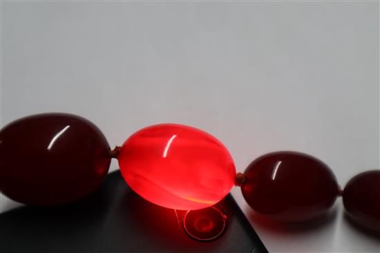 A single strand graduated simulated cherry amber necklace, gross weight, 114 grams, 82cm.